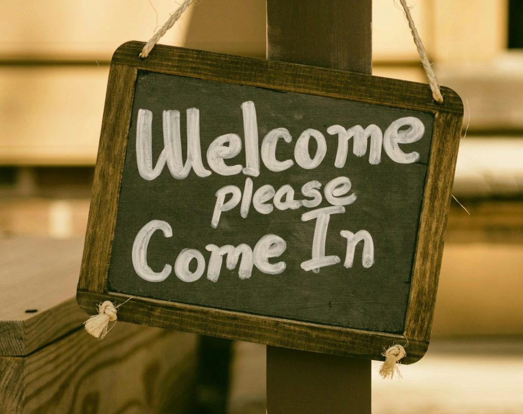 A sign, saying 'Welcome. Please come in'.