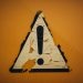 Rusty metal iron weathered sticker "caution" ! by Markus Spiske