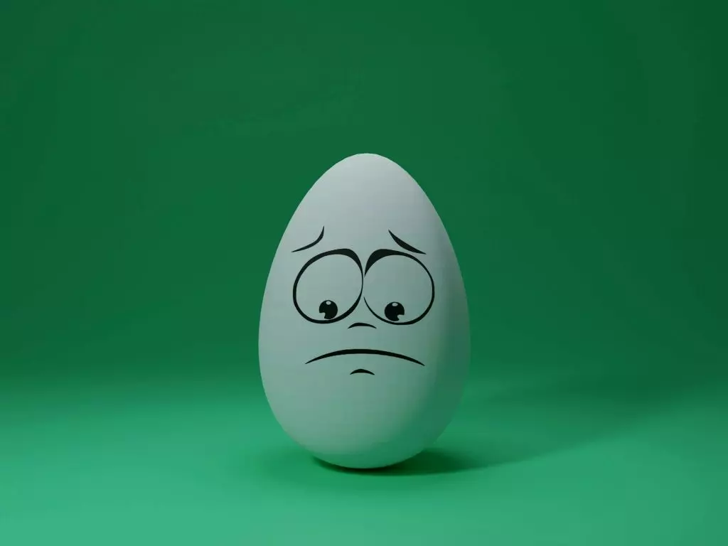 Title Image for article: Reacting to OCD Thoughts (part 1). An egg with a sad face drawn on it. By Shubham Dhage